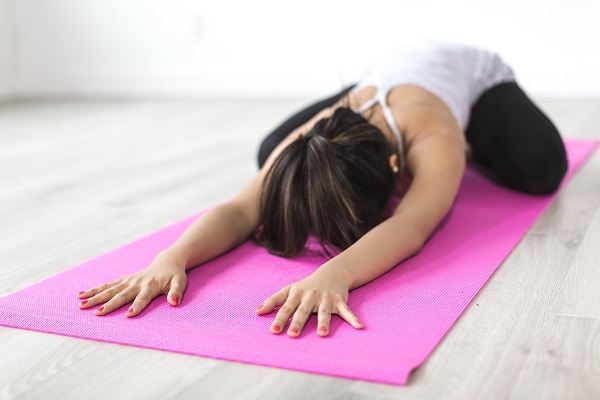 Een vrouw die zich uitrekt op een roze yogamat