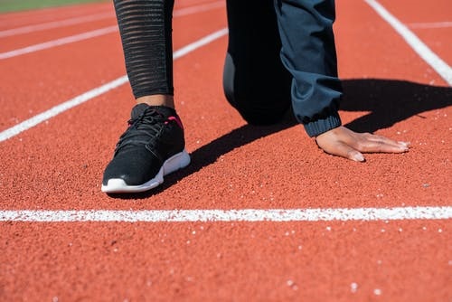 Een blik op de startlijn van een atletiekpiste met zicht op een hardloopschoen