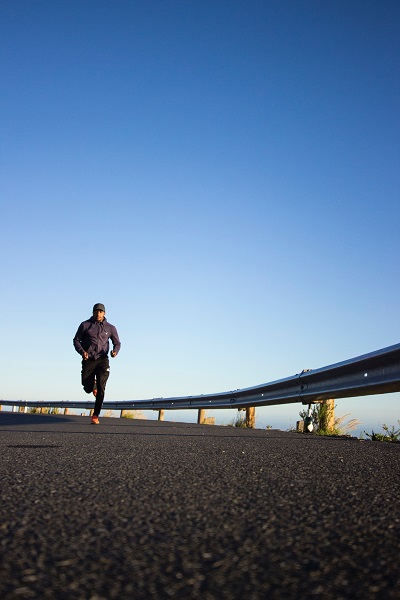 man loopt in modieuze kledij op de weg